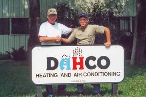 Carl shaking hands with Denny's Heating & Cooling Co who sold his Newton business to Hanna