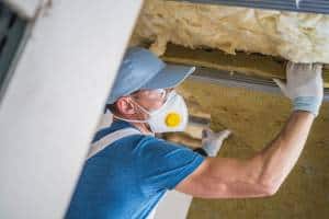 Photo of technician installing insulation to help heat a home
