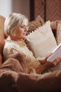 Woman relaxing on the couch enjoying good air quality in her Wichita home while reading a book