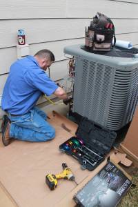 Hanna AC tech working on outside air conditioning condenser unit