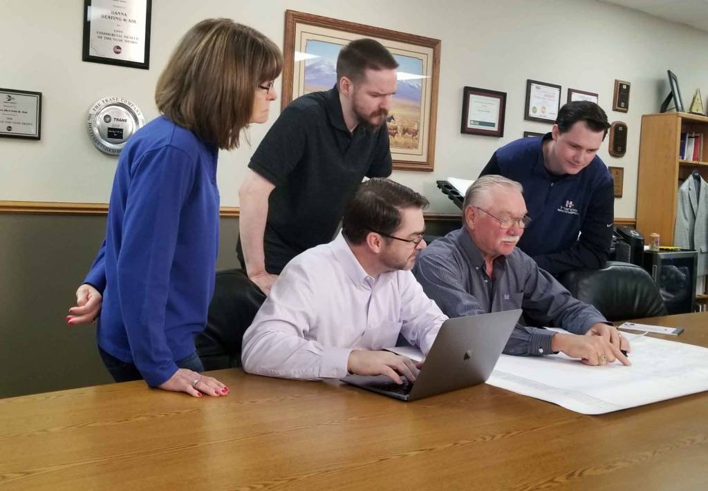 Hanna Heating & Air managers and founder looking at home plans for design of new HVAC system installation